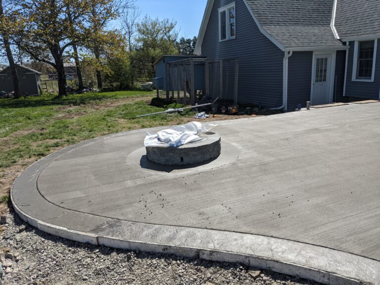 Broomed concrete patio with fire pit pad