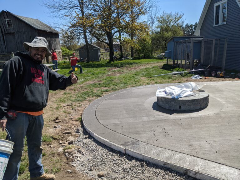 Broomed concrete patio with integrated stone fire pit pad