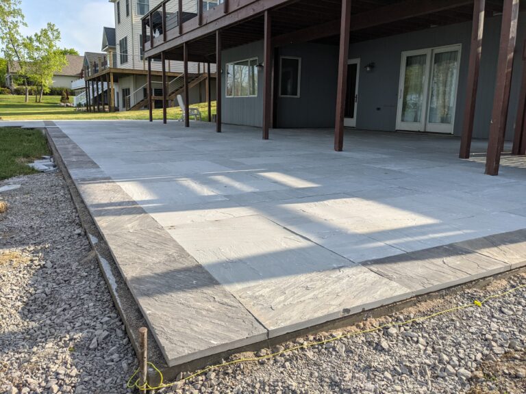 Stamped concrete patio with ashlar slate pattern and decorative stone border