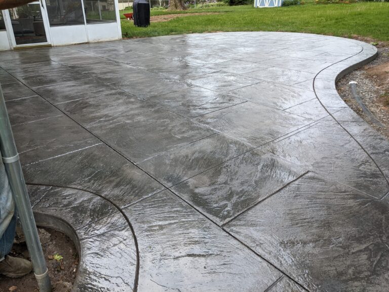 Completed stamped concrete patio with slate pattern and curved border
