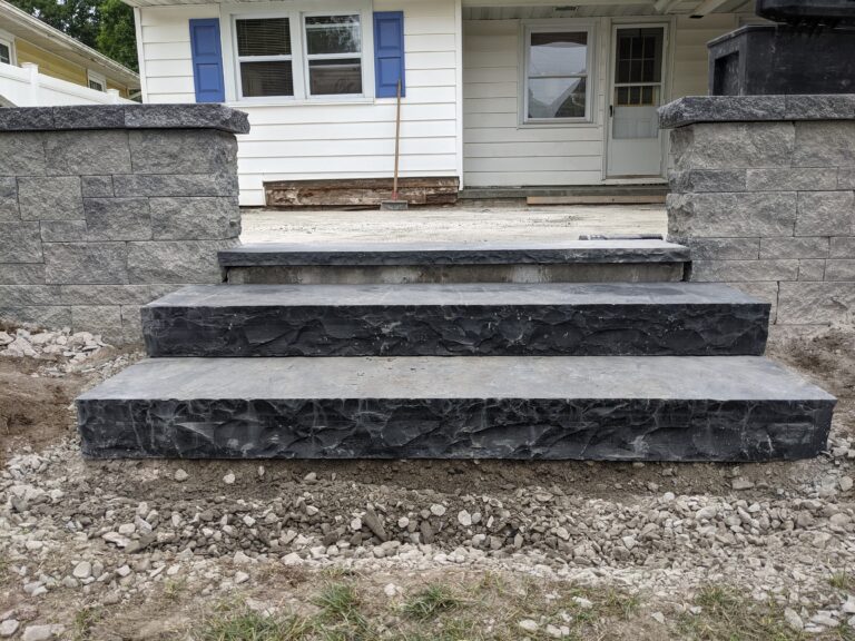 Three-tier natural stone veneer steps with charcoal face and grey cap stones