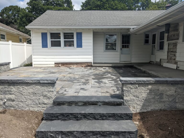 Raised natural stone patio with block retaining walls and stone veneer steps