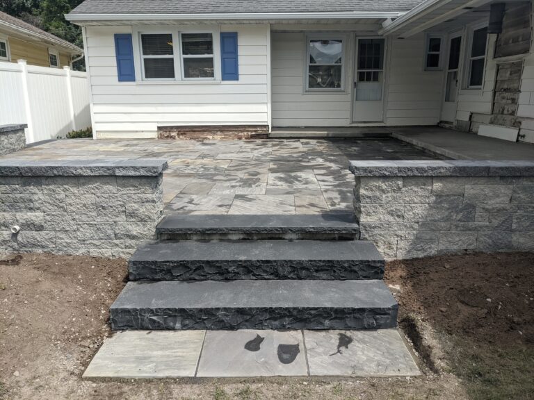 Raised stone patio with block walls, stone veneer steps, and flagstone surface