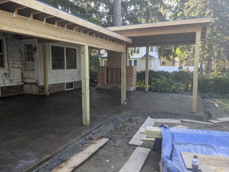 Newly poured broomed concrete patio extending under covered porch
