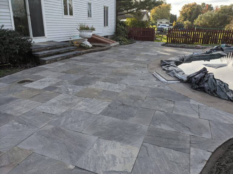 Completed natural flagstone patio with stone steps and decorative pond