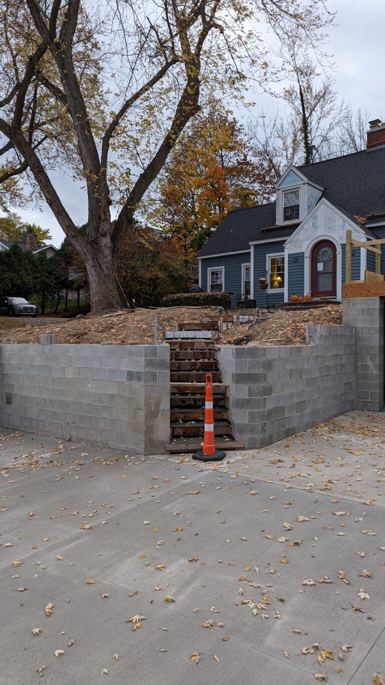 Concrete pad at base of block retaining wall with stairway opening