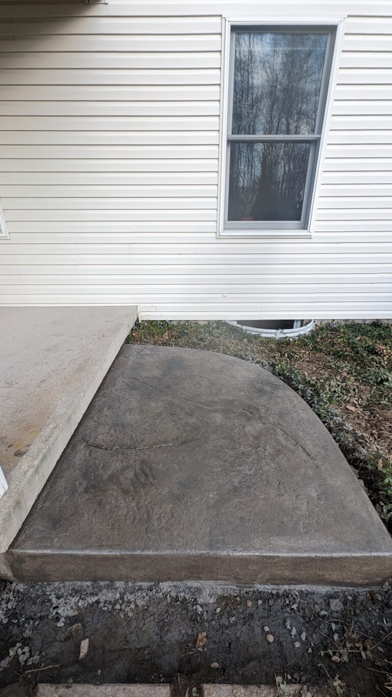 Stamped concrete step with rounded profile and stone pattern