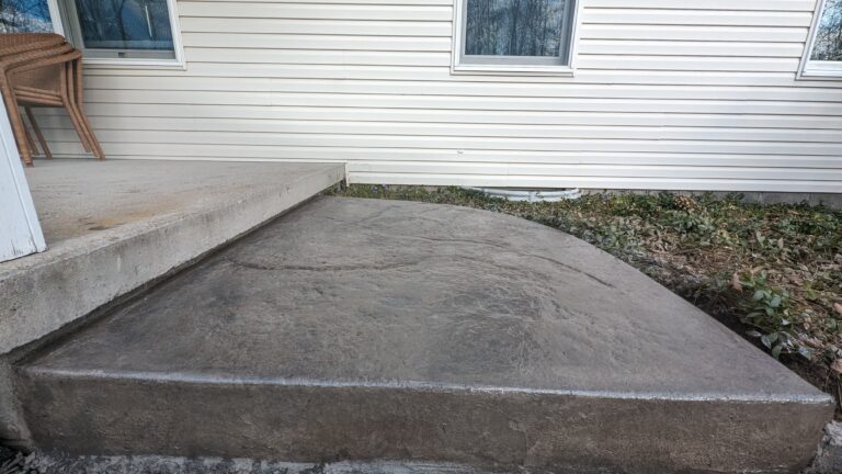 Stamped concrete step landing with stone texture and rounded edge