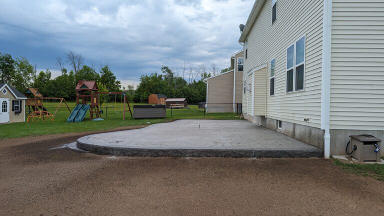 Wide view of concrete patio with curved edge and aggregate border