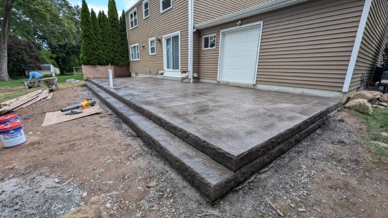 Raised stamped concrete patio with stone-textured step risers
