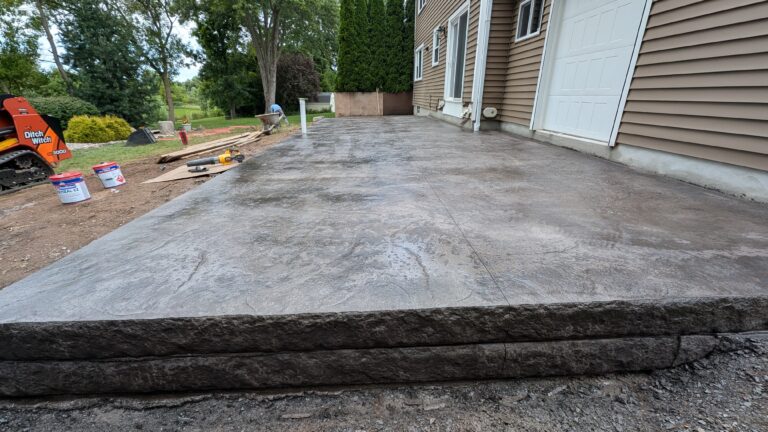 Raised concrete patio with stamped stone veneer step faces