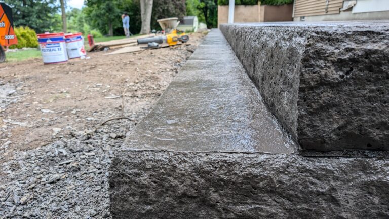 Low-angle view of stamped concrete step with stone veneer texture