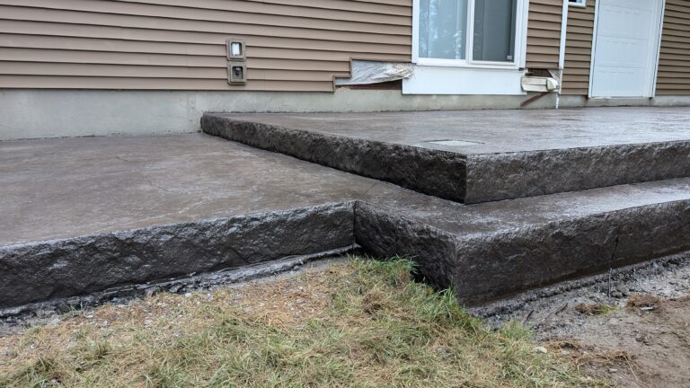 Raised stamped concrete patio with two-tier stone-textured steps