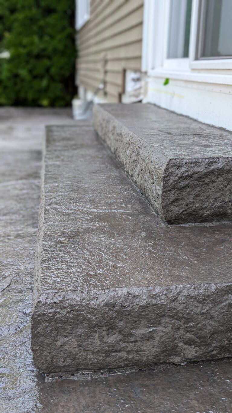 Portrait close-up of stamped concrete step with stone veneer edge