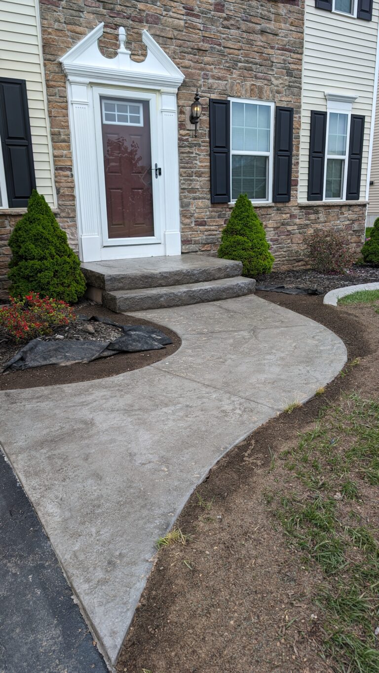 Curvy front walkway with stamped concrete steps