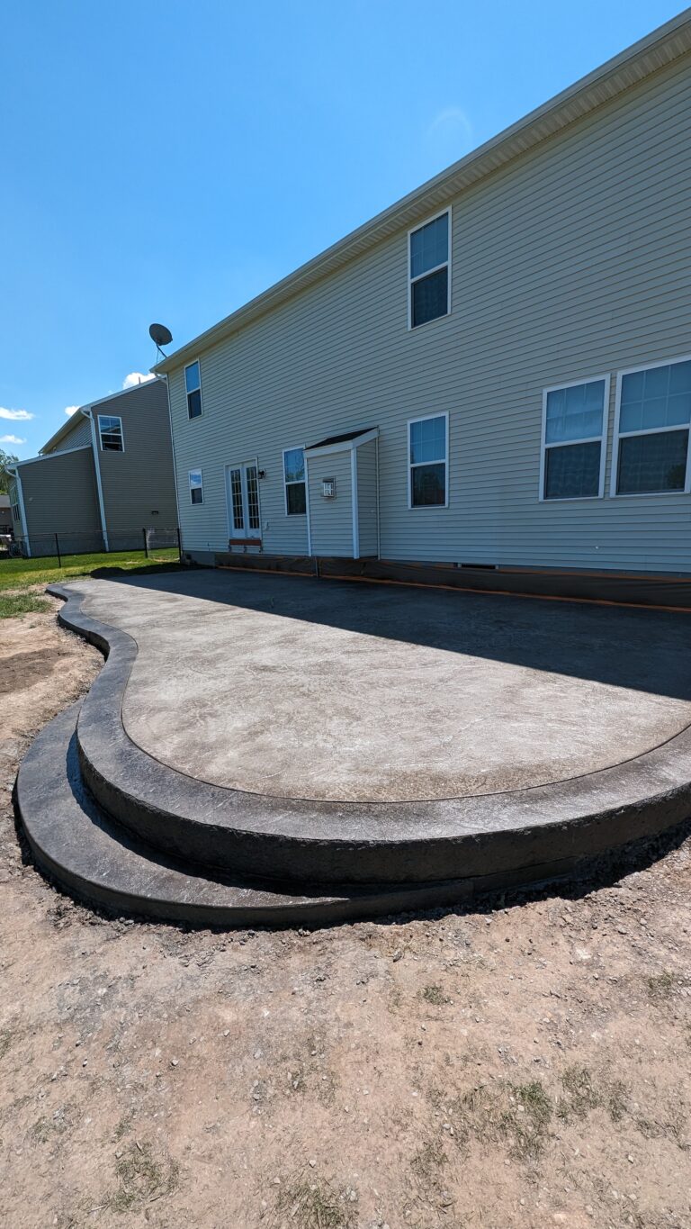 Curvy stamped concrete patio with border and steps