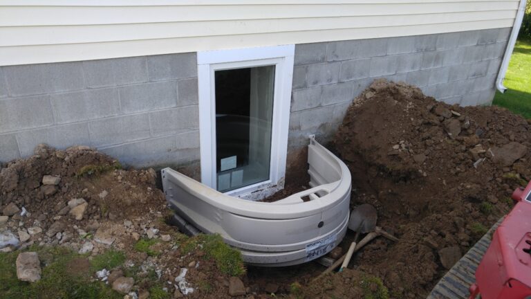 Egress window well installation at block foundation