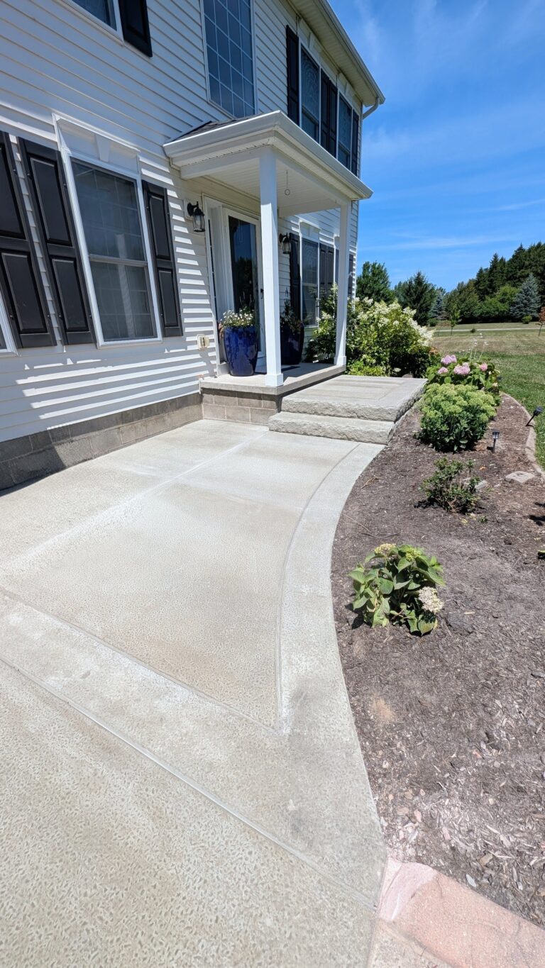 Curved concrete walkway with step leading to front porch