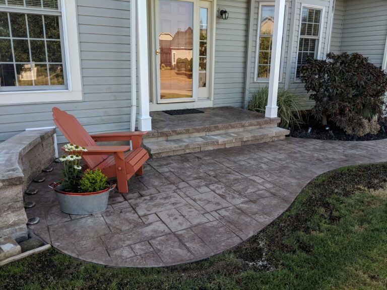 Stamped concrete front patio with stone seat wall