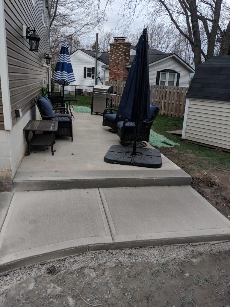 Concrete patio with step and outdoor furniture