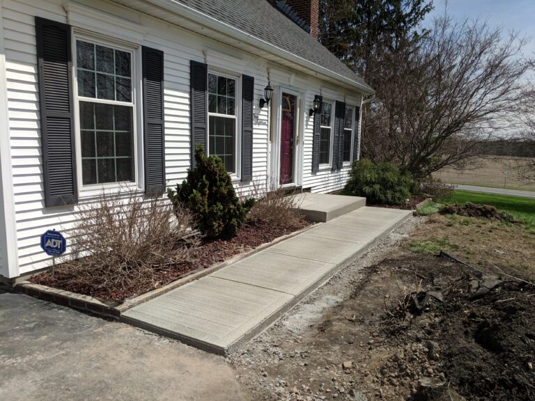 Concrete front walkway with landscaping