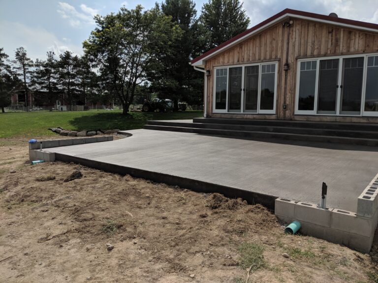 Large concrete patio with steps at rural property