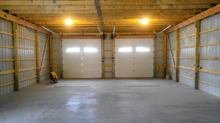 Interior of a pole barn with two overhead garage doors and a newly poured smooth concrete floor slab in Rochester NY