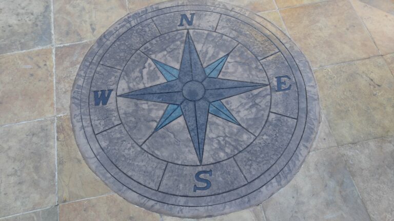 Decorative compass rose inlay stamped into flagstone pattern concrete patio with blue accent – Rochester NY