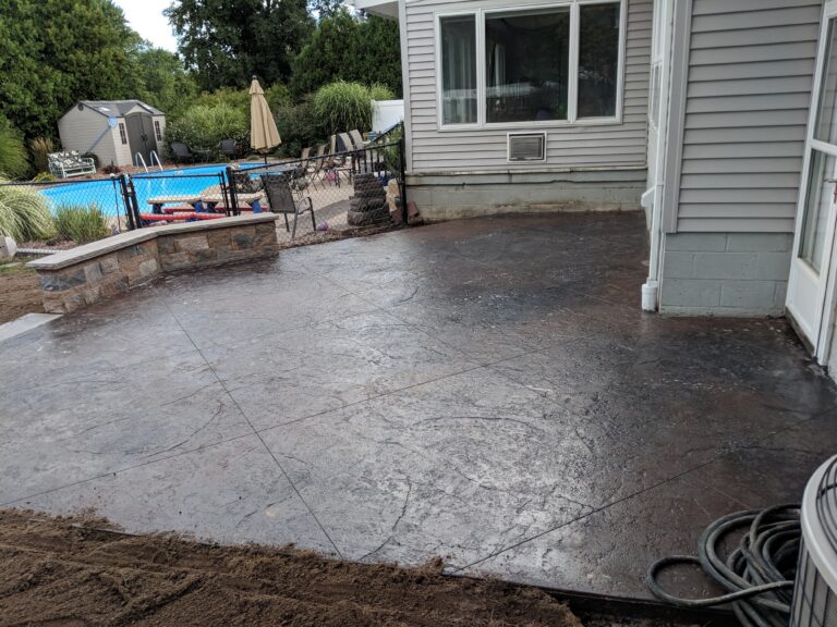 Close-up of freshly poured stamped concrete pool deck with large-format stone pattern in Rochester NY
