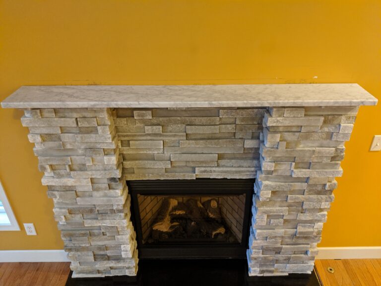 Stacked ledgestone fireplace surround with polished marble mantel shelf, Rochester NY home interior