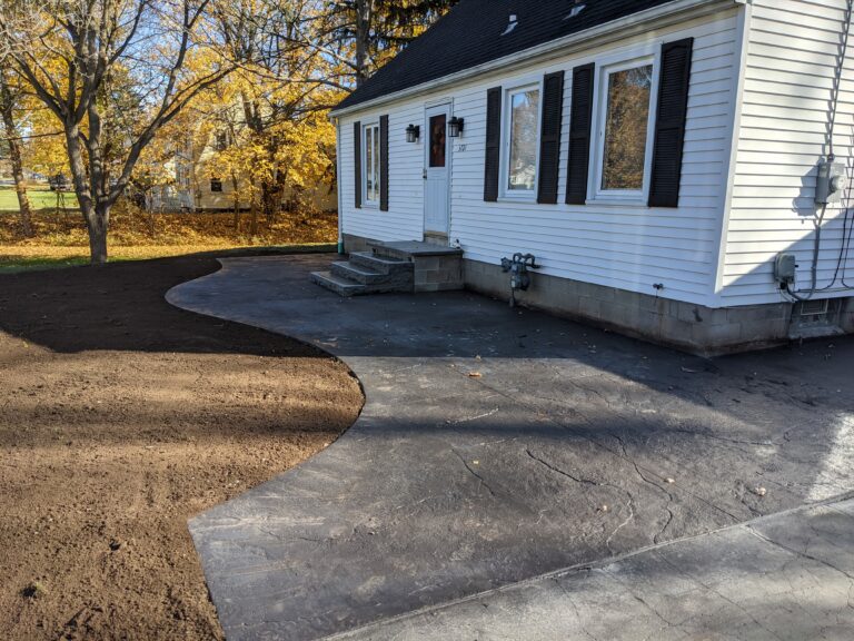 Stamped concrete patio and entry step at residential home with autumn landscaping – Rochester NY