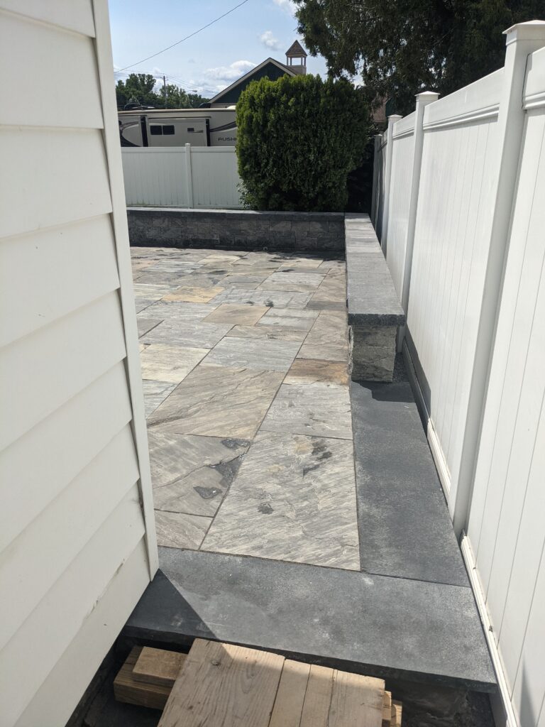 Natural bluestone patio with large rectangular slabs being installed next to sunroom, Rochester NY