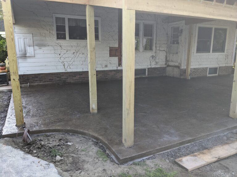 Stamped concrete patio poured under new covered outdoor addition framing – Rochester NY