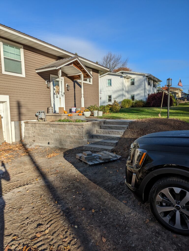 Concrete block entry steps and raised seat wall under construction at front of home, Monroe County NY
