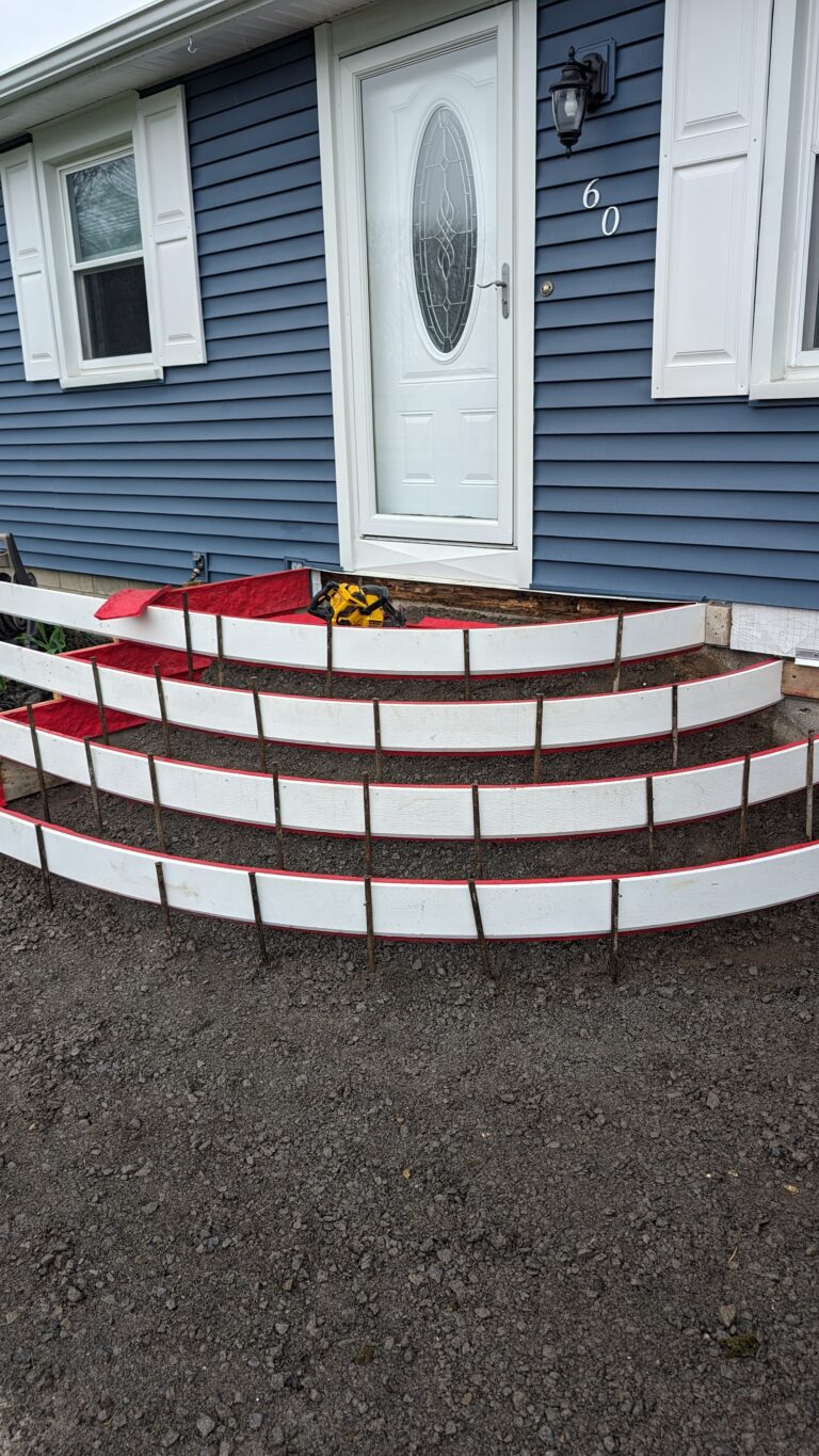 Curved red concrete forms staked and ready for three-tier entry step pour at a Rochester NY home