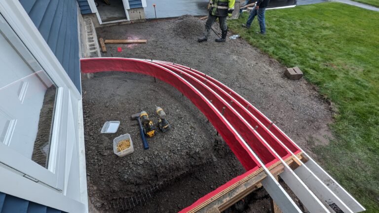 Curved red concrete step forms set on compacted sub-base with rebar in place, Rochester NY residential project