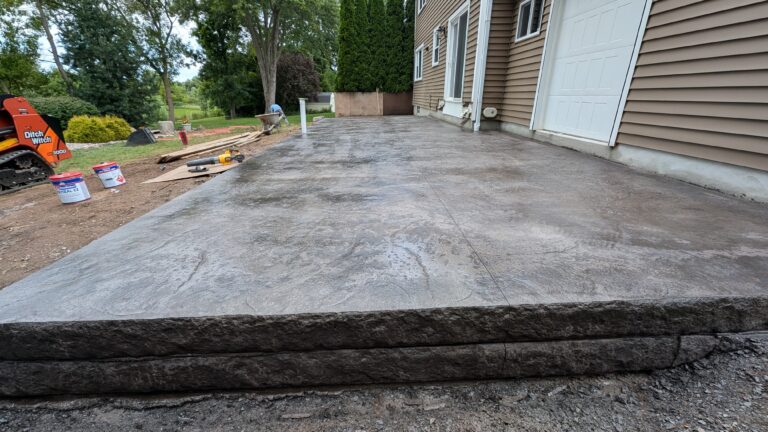 Large stamped concrete patio with chiseled stone-face step riser detail – Rochester NY