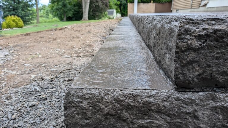 Side view of stamped concrete steps with stone-face textured risers leading to patio – Rochester NY