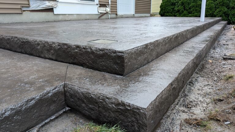Front angle view of dark charcoal stamped concrete steps with chiseled stone-face risers – Rochester NY