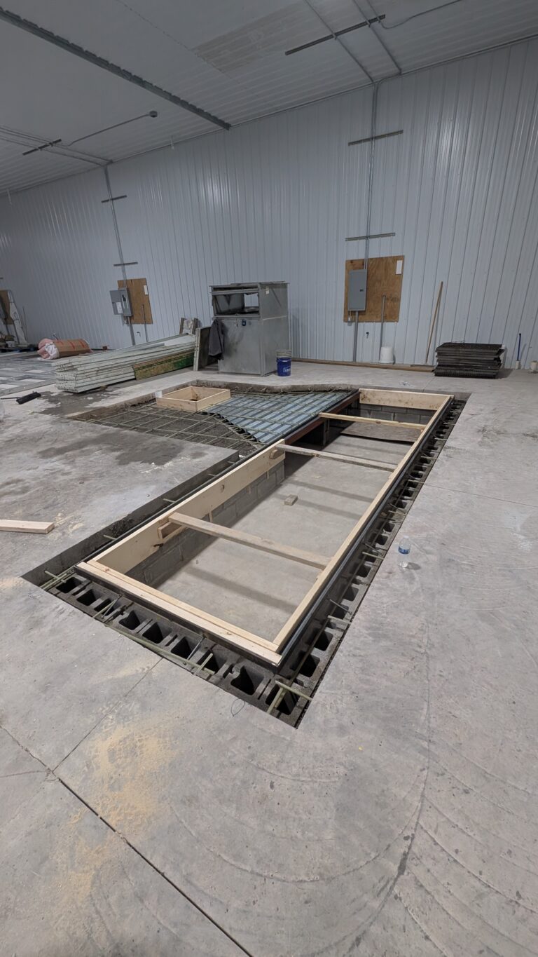 Wide view of commercial in-ground pit foundation formwork with ICF block walls and rebar – Rochester NY