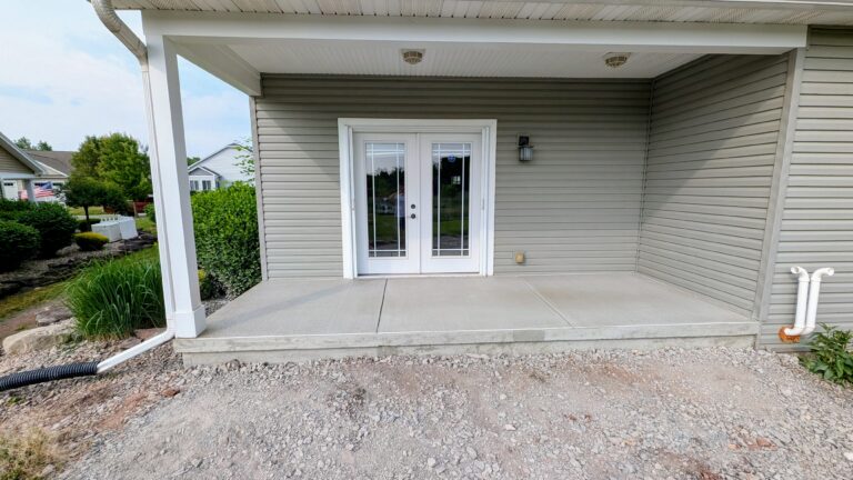 Fresh broomed concrete covered patio with French doors on a residential home in Rochester NY area