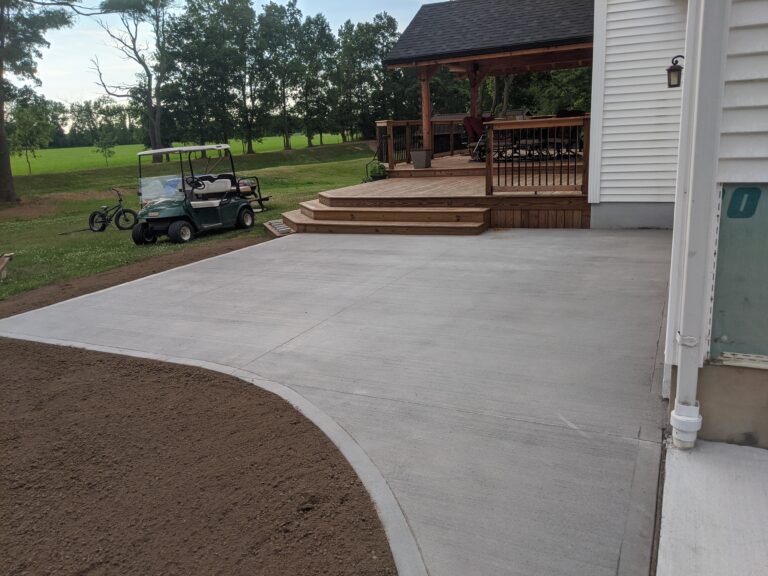 Flat broomed concrete patio adjacent to a wood deck and covered gazebo at a Rochester NY home