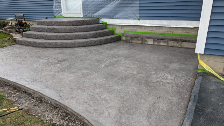 Freshly poured slate-stamped concrete stoop with rounded fan steps at residential home, Rochester NY